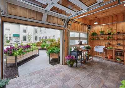 Interior view of a greenhouse with plants and wooden decor