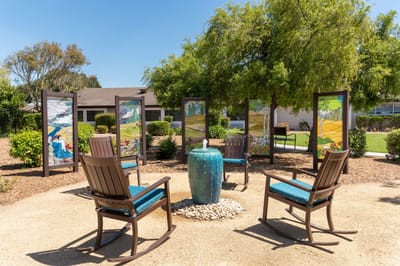 Outdoor seating area with art panels and rock feature