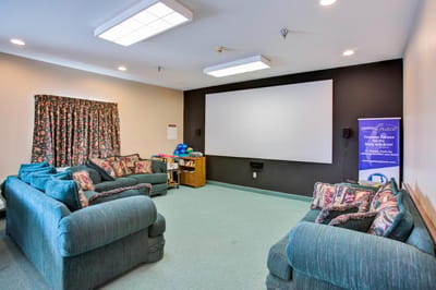 Interior of a common area with seating and a screen