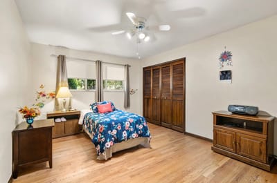 Cozy private bedroom with floral decor and wooden furniture