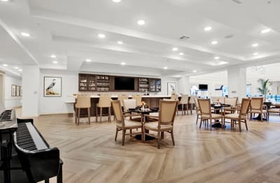 Bright dining area with seating and piano