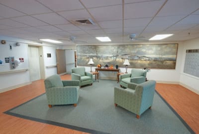 Common area with chairs and a large mural