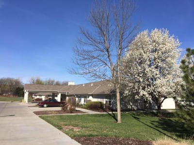 Exterior view of a senior living facility with a flowering tree