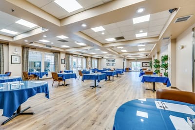 Bright dining room with blue tablecloths and ample seating