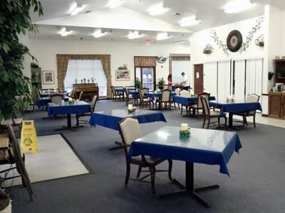 Dining area set up with blue tablecloths and chairs