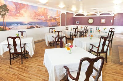Bright dining room with tables set for residents