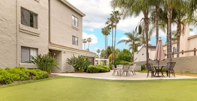 Outdoor seating area with palm trees and greenery