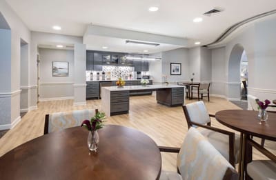 Bright common area with tables and modern kitchen