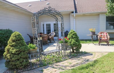 Outdoor sitting area with decorative arch and chairs
