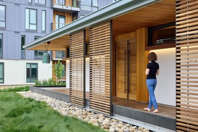 A person walking towards the entrance of a modern building