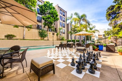 Outdoor chess area with seating and building in background