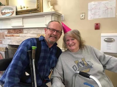 Two residents celebrating with party hats in a common area