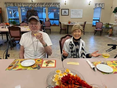 Residents enjoying a meal in the dining room, smiling and engaging