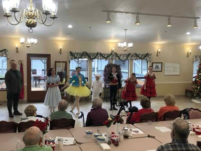 Residents enjoying a performance in a common area during the holidays