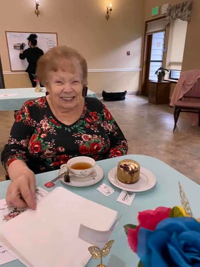 Resident enjoying tea and dessert in a cozy dining area