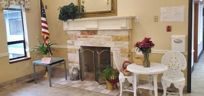 Cozy common area with seating, plants, and a fireplace