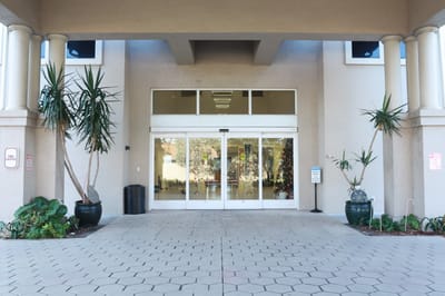 Entrance of the facility with plants and glass doors