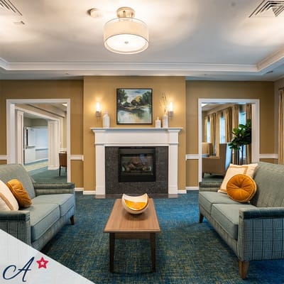 A cozy common area with comfortable seating and a fireplace