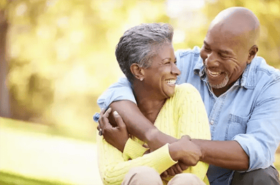 A joyful couple embracing outdoors in a park