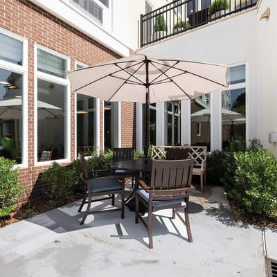 Outdoor seating area with an umbrella and greenery