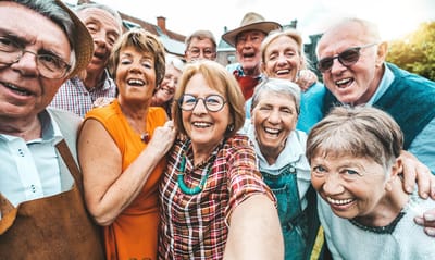 Residents and staff smiling together in a group selfie