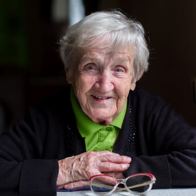 An elderly woman with a warm smile