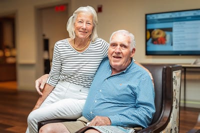 Elderly couple smiling together in a common area