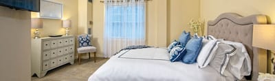 Well-decorated resident room with bed and furniture