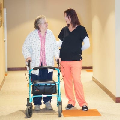 Staff assisting a resident in a corridor
