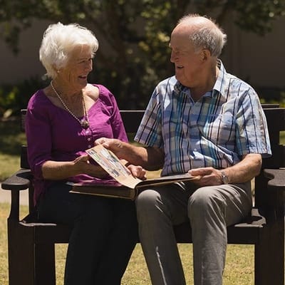 Seniors enjoying time together outdoors with a book