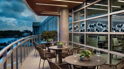 Outdoor patio area with tables and chairs overlooking the water