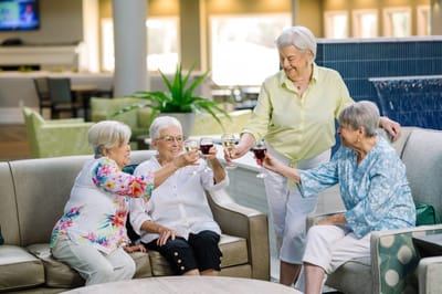 Residents toasting with drinks in a common area