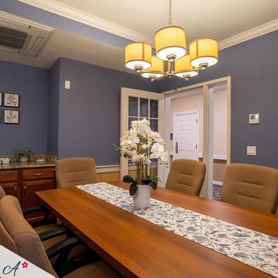 Bright dining room with a wooden table and flower centerpiece