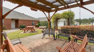 Outdoor seating area with swings and picnic tables
