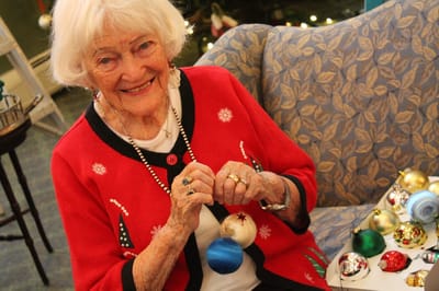 Resident decorating for the holidays in a cozy lounge