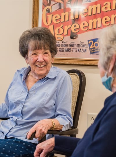Two residents chatting in a cozy common area