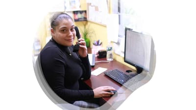 Staff member at a desk using a phone
