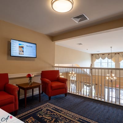Common area with red chairs and television screen