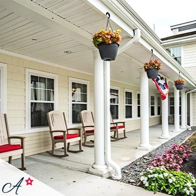 Covered porch area with rocking chairs and flower pots