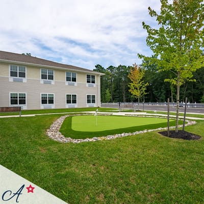 Green outdoor space with putting green and building in background