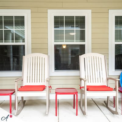 Rocking chairs on a porch near windows