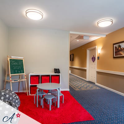 Bright activity room with a red carpet and seating