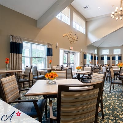 Bright common area with dining tables and floral centerpieces