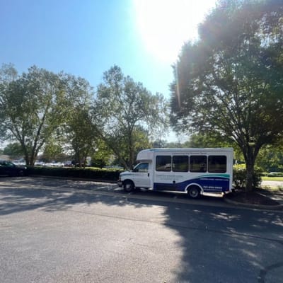 Facility transport vehicle parked under trees