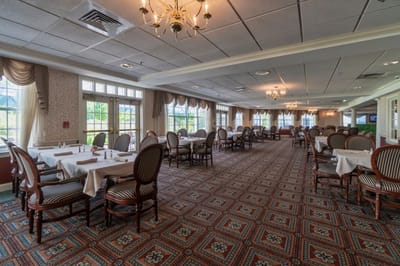 Bright dining room with tables and chairs set up