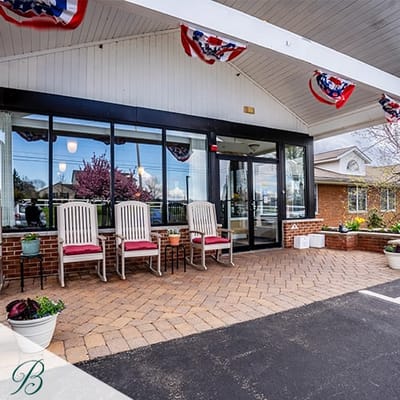 Front entrance of Bentley Assisted Living at Branchville with seating