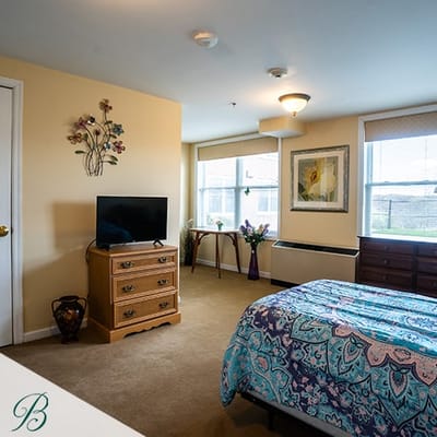 A private resident room with a bed and TV