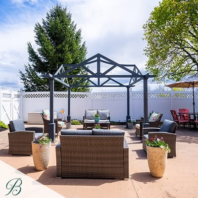 Outdoor seating area with shaded pergola and plants