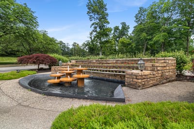 Outdoor water feature with seating area and greenery
