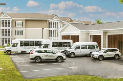 Facility transport vehicles parked in front of building